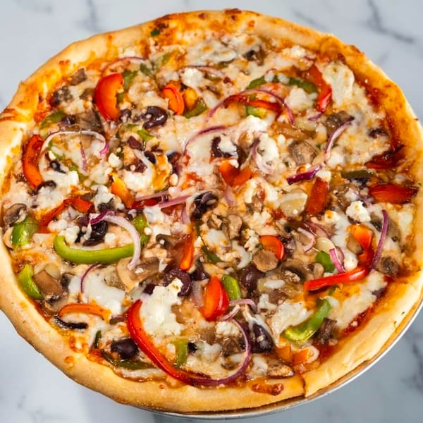 Wael's Mediterranean Cuisine pizza topped with colorful bell peppers, red onions, olives, and feta cheese.